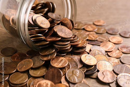 Fotomural Glass jar with coins on table, closeup. Money saving concept