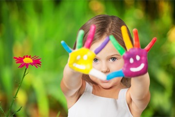cute little girl with colorful painted hands on background