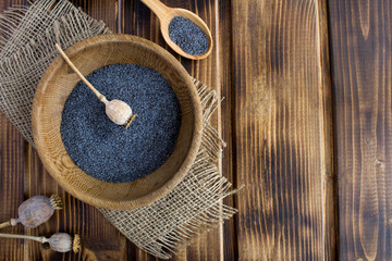 Wall Mural - Poppy  seeds in the brown bowl on the rustic wooden background.Top view.Copy space