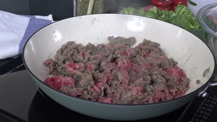 Wall Mural - Thin slices of shaved beef simmering in a cast iron skillet