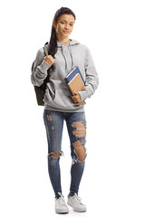 Wall Mural - Young female with backpack and books smiling at the camera