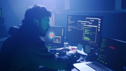 Profile of stressed hacker trying a virus attack on corporate servers in dark place. Night hacking fail in the office.