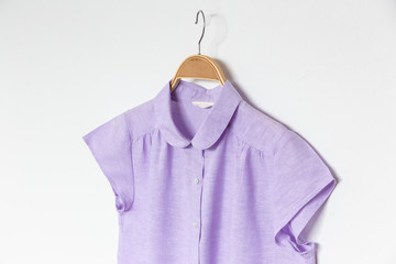  Purple blouse with wooden hanger isolated white background.