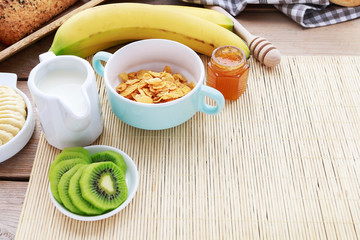 Sticker - Healthy breakfast: bowl of corn flakes, jug of milk, sliced fruits, jar of honey.