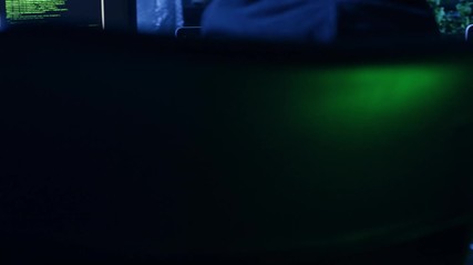 Close-up of a concentrated programmer working in a software development studio sitting at the table. IT developer working on computer.