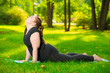 © kosmos111 - work on yourself - a sports woman plus size in the park performs stretching exercises