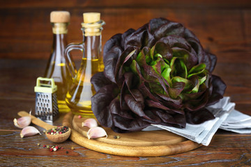 Wall Mural - Fresh red lettuce head, oil and seasoning on the wooden table