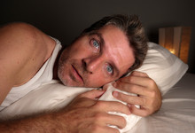 Close Up Face Portrait Of Sleepless And Awake Attractive Man With Eyes Wide Open At Night Lying On Bed Suffering Insomnia Sleeping Disorder Trying To Sleep