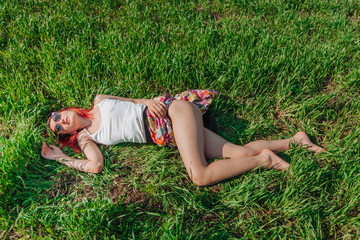 girl lies on the green grass