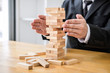 Alternative risk concept, plan and strategy in business protect with balance wooden stack with hand control risk shape