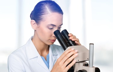 Wall Mural - Female and male scientists in glasses working with microscope