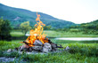 Burning fire in nature on the background of the lake The embers in the fire. Burning coal in the bonfire. 
