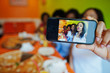 © AS Photo Family - Close up photo phone screen of four young african girls in bright colored restaurant eating pizza, having fun together and making selfie.