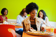 © AS Photo Family - African woman with pizza sitting at restaurant against dark skinned girls.