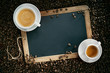 Chalk board or slate with cups of coffee and beans