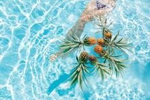 Woman's Legs Near Floating Pineapple