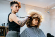 © Santi Nunez/Stocksy - Beautiful afro woman getting haircut by hairdresser in the beauty salon