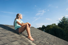 Roof: Girl Sits On The Roof Of A House Daydreaming