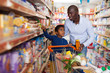 © JackF - Cheery African American man and son in store
