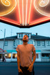 © Jesse Morrow/Stocksy - portrait of young male under neon light