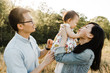 © Erin Drago Photography/Stocksy - Happy Asian Family Snuggling, Cuddling and being Playful Outdoors