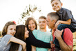 © Erin Drago Photography/Stocksy - Family doing Fun Pose in Field