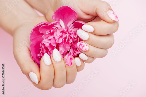 Αφίσα Peony flower in beautiful woman's hands with trendy nail art on pink background
