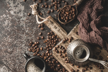 Coffee on wooden board with coffee beans on dark textured background. Top view with copy space. Background with free text space.