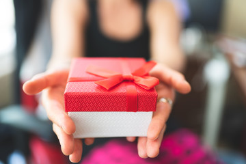 woman holding a red gift box 