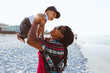 © Gerald Carter/Creative Flame - Black mom entertaining baby on beach