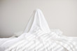 © Kelly Knox/Stocksy - Boy hiding under sheet on bed