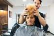 © Santi Nunez/Stocksy - Beautiful afro woman getting haircut by hairdresser in the beauty salon