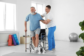professional physiotherapist working with senior patient in rehabilitation center
