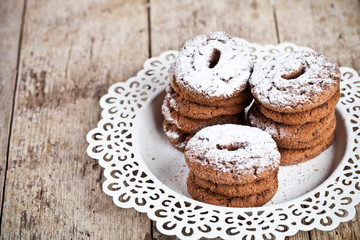 Wall Mural - Fresh baked chocolate chip cookies with sugar powder heap on white plateon rustic wooden table background.