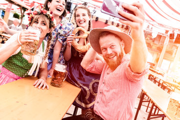 Wall Mural - Gruppe von Freunden machen Selfies auf dem Oktoberfest im Bierzelt mit Bier beim Feiern 