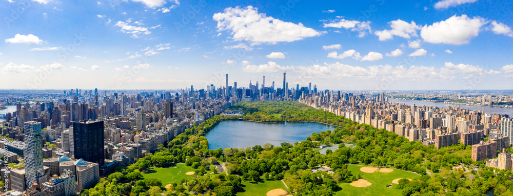 Central Park aerial view, Manhattan, New York. Park is surrounded by skyscraper. Beautiful view of the Jacqueline Kennedy Onassis Reservoir in the center of the park. - obrazy, fototapety, plakaty 