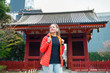 Tokyo, Japan Asakusa area with Sensoji temple shrine with red architecture and happy young tourist woman standing