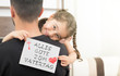 german lettering, fathers day happy birthday message.little girl hugging her father and showing the message of congratulation