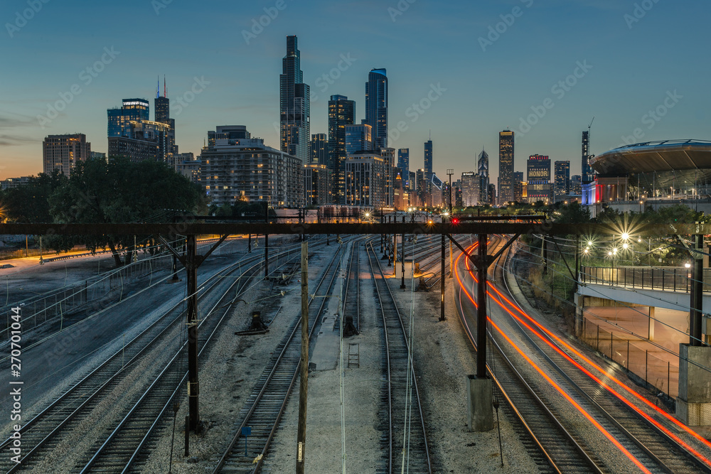 Various train tracks leading into downtown in the evening - obrazy, fototapety, plakaty 
