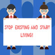 Handwriting text Stop Existing And Start Living. Concept meaning Enjoy have more leisure family moments Male and Female in Uniform Standing Holding Blank Placard Banner Text Space