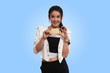 © skarie - Fashion, shopping, banking and payment concept. Smiling beautiful Asian woman presenting credit card in hand isolated on light blue background.