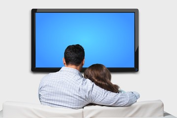 Young couple watching TV at home