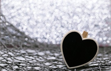 Black heart in silver glitter blur background