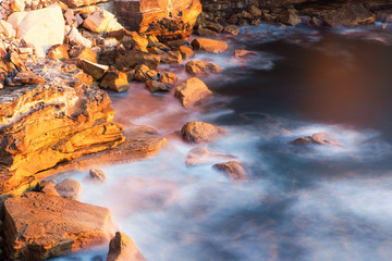 Canvas Print - long exposure view of wave water around rocks.