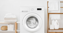 Washing Machine With Laundry And Shelves On White Wall Background