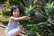 Leinwandbild Motiv Asian Chinese Little Girl holding pineapple on the farm