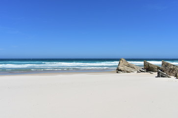 Wild beach with white sand, rocks and waves. Lugo, Spain.