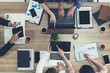 © InfiniteFlow - Top view of businessman executive in group meeting with other businessmen and businesswomen in modern office with laptop computer, coffee and document on table. People corporate business team concept.