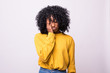 © F8  \ Suport Ukraine - Sad pretty girl feeling upset while spending time at home alone. Beautiful young dark-skinned female with Afro hairstyle staring at camera with unhappy or regretful look against studio wall