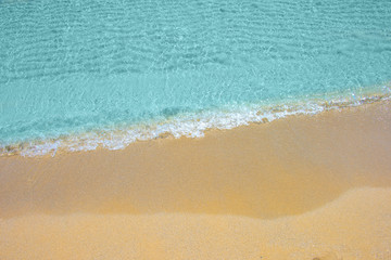 Soft wave of turquoise sea water on the sandy beach